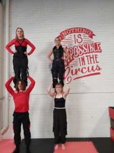 Four teenagers perform two highs next to the Nothing is Impossible in the Circus sign at Roundbouat Circus in Wyoming NSW. The teen class is a popular addition to our weekly schedule.